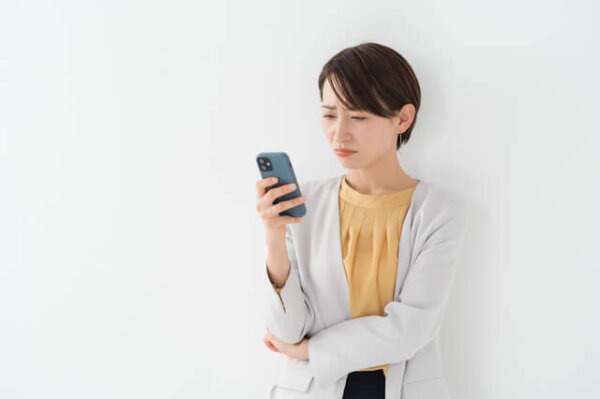 不信そうにスマホを見る女性